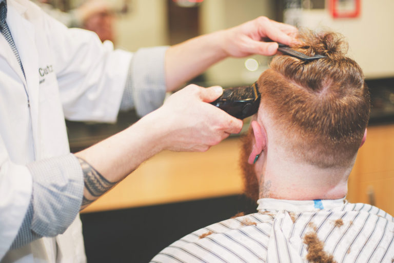 Barber giving customer a fade cut