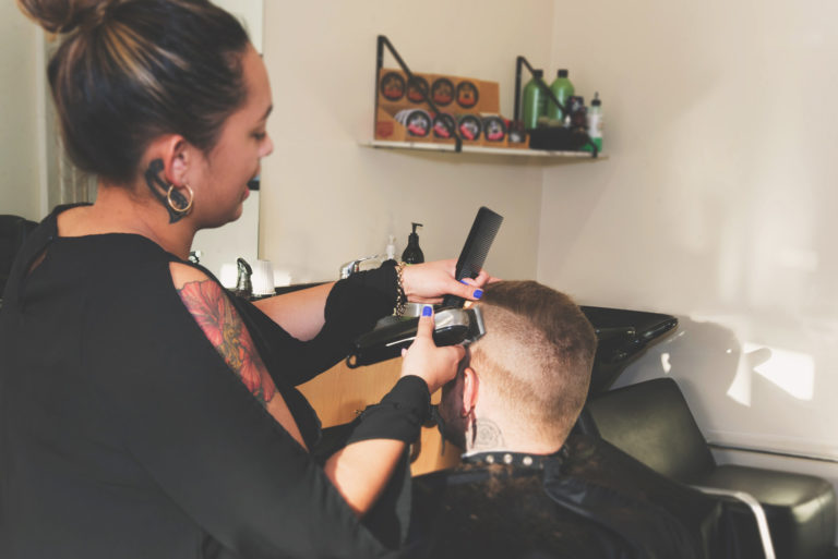 Barber giving customer a fade clipper cut